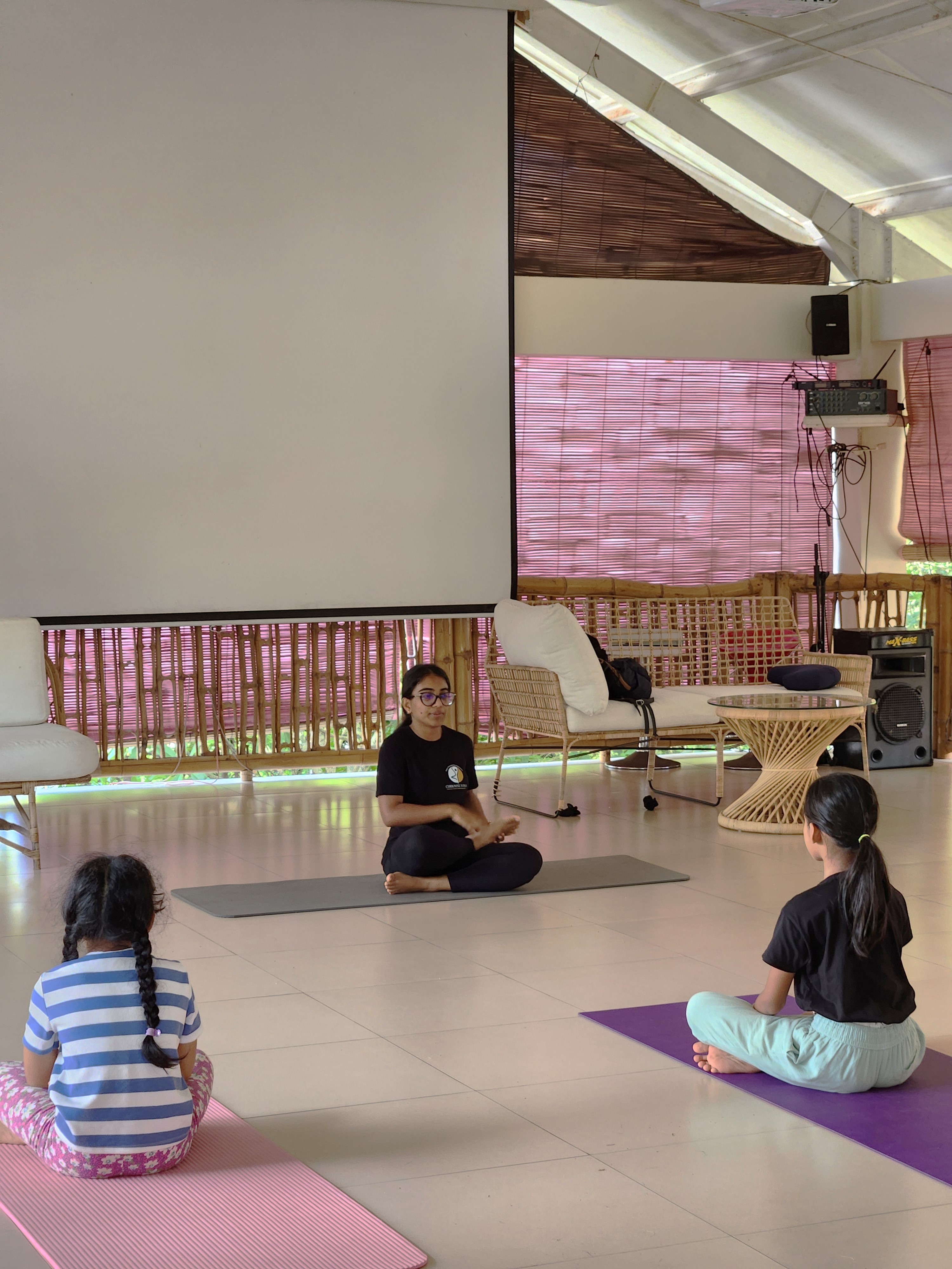 young kids meditating on their yoga mats in a open room